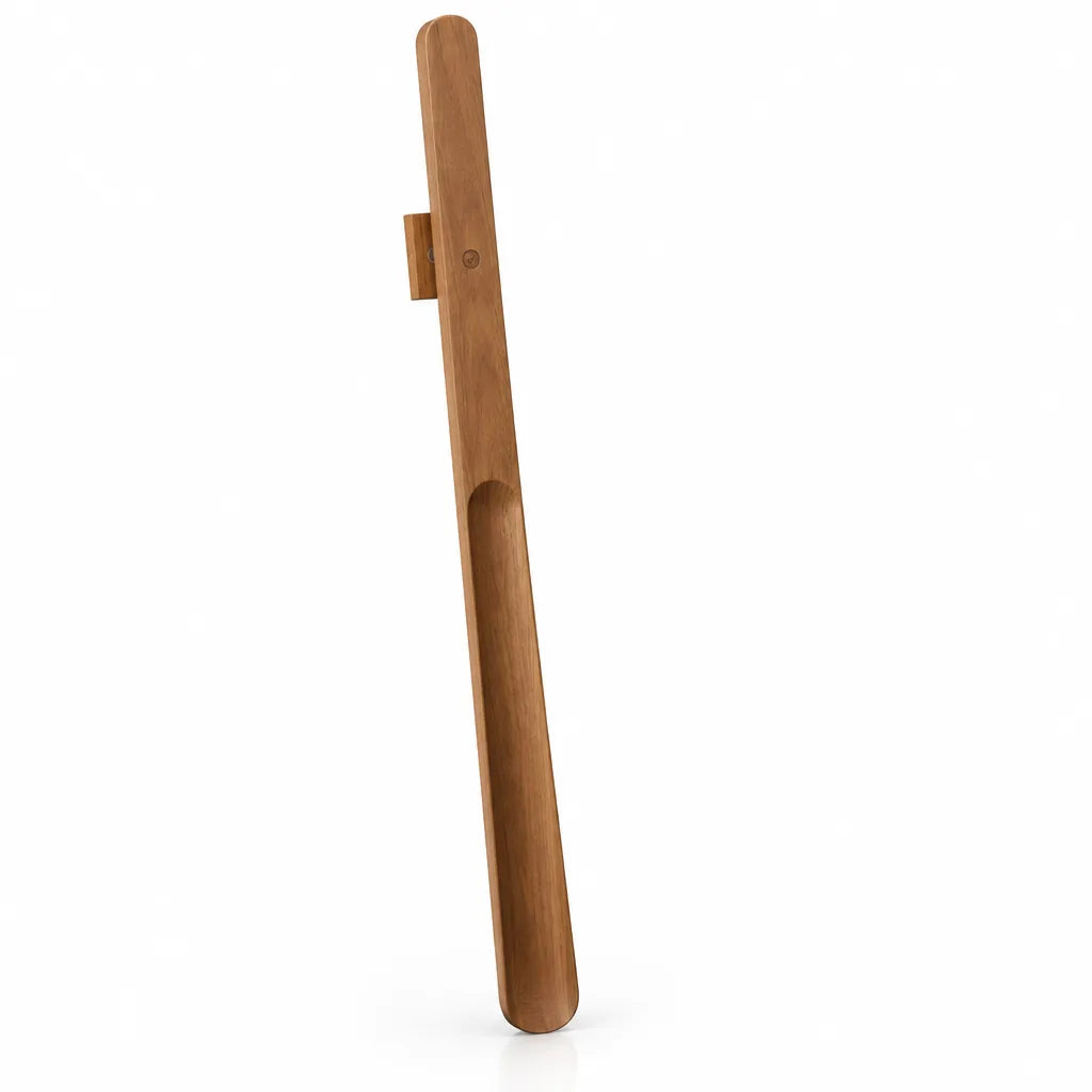 An extra-long walnut wood shoehorn standing upright against a plain white background, showing its smooth curved scoop, long tapered handle and the small magnetic wall mount holding it near the top.