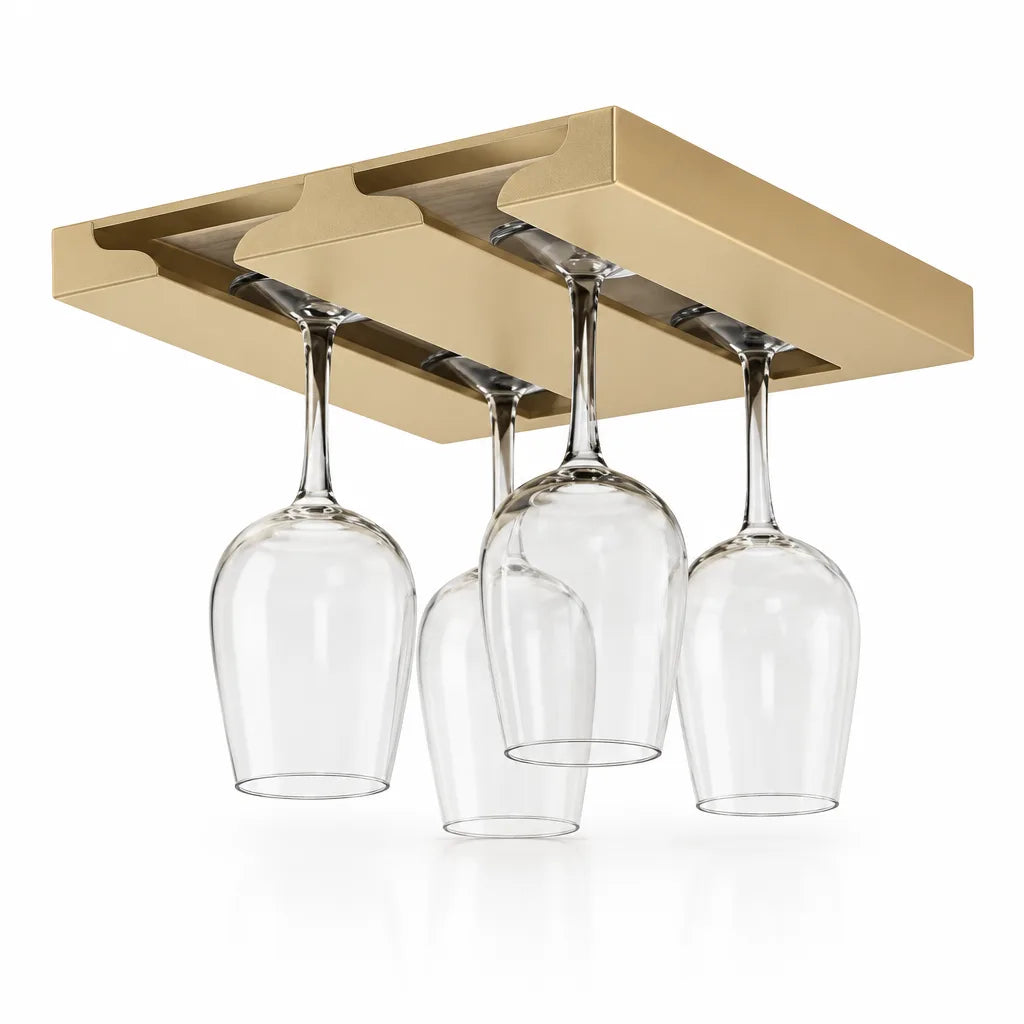 Gold two-slot wine glass rack mounted under a cabinet panel, with four clear stemmed glasses hanging upside down from its grooved rails against a white background.