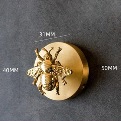 Round Solid Brass Animal Head Coat Hook with a raised bee on its face, mounted on a dark grey wall and labelled with dimension lines reading 31MM, 40MM and 50MM.