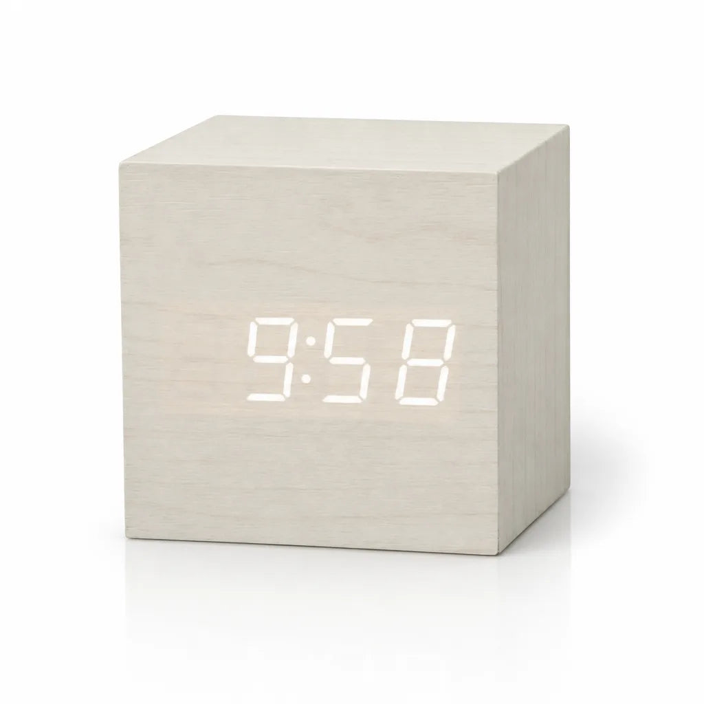 A white wood-finish digital LED alarm clock shown as a single cube on a plain white background, with the time 9:58 glowing in white digits on its front face.