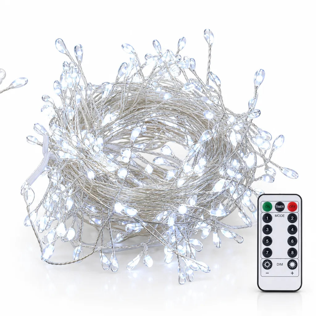 A coiled bundle of LED copper wire string lights with hundreds of teardrop-shaped bulbs lit in cool white, shown on a white background beside a slim white remote control with on, timer, off, numbered mode and dimming buttons.