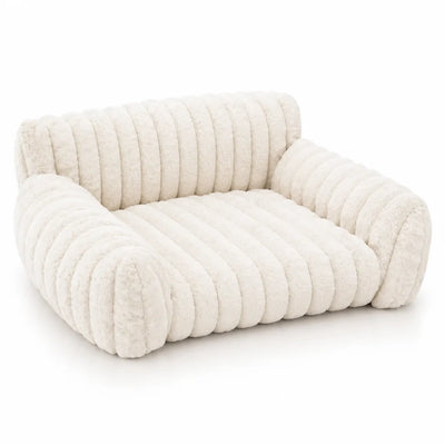 Milky white plush pet bed in a sofa design, shown from the front against a plain background, with thick ribbed faux fur channels across the seat, backrest and rounded armrests.